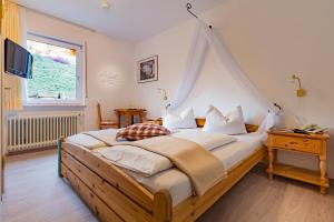 - une chambre avec un grand lit à baldaquin dans l'établissement Hotel Villa Tummelchen, à Cochem