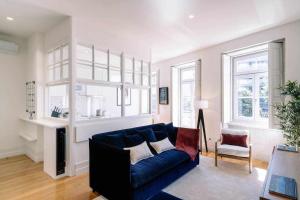 Una sala de estar con un sofá azul y dos ventanas en Bruno's Wine House, en Vila Nova de Gaia