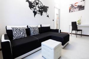 een woonkamer met een zwarte bank en een wereldkaart aan de muur bij HomeHoliday - MY PLACE SANREMO in Sanremo