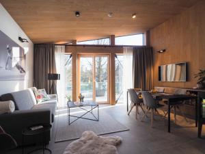 a living room with a couch and a table at CHALEYOTT Mountain Apartments in Harrachov