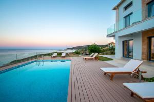 una piscina su una terrazza con vista sull'oceano di Villa Vrahos - Deja Vu Villas a Agios Nikolaos