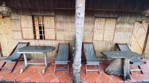 een tafel en stoelen voor een gebouw bij mekong riverside homestay in Vĩnh Long