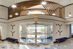 Comfort Suites Newport News Airport في نيوبورت نيوز: مدخل مستشفى فيه كراسي زرقاء في اللوبي