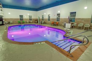 - une grande piscine d'eau violette dans un bâtiment dans l'établissement Comfort Suites Newport News Airport, à Newport News