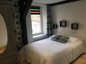 een slaapkamer met een wit bed en een raam bij Au coeur des Remparts in Boulogne-sur-Mer