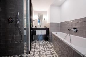 een badkamer met een bad en een wastafel bij Prevôt Restaurant & Hotel in Keulen