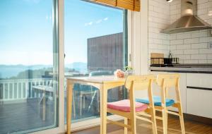 une cuisine avec une table en bois et deux chaises dans l'établissement Namhae Whale's Dream, à Namhae