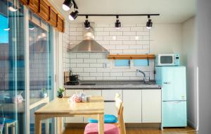 uma cozinha com uma mesa e um frigorífico em Namhae Whale's Dream em Namhae