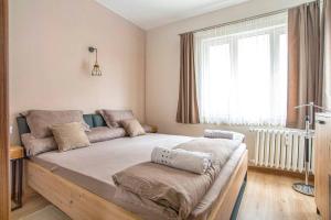 a large bed in a room with a window at Elegant & Stylish 2 Bedroom Top Central Apartment in Sofia +6 photos