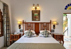 a bedroom with a bed with two pillows at Amet Haveli - A Heritage Hotel Udaipur in Udaipur +77 photos