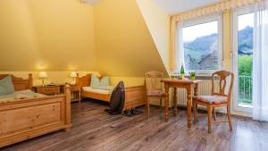 Schlafzimmer mit einem Bett, einem Schreibtisch und einem Tisch in der Unterkunft Hotel Villa Tummelchen in Cochem
