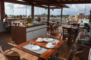 a restaurant with tables and chairs on a balcony at Pousada Viva Maragogi in Maragogi