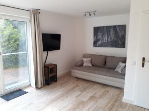 uma sala de estar com um sofá e uma janela em Ferienwohnung Zürcher em Chieming