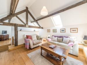 a living room with a couch and a table at Foxholes Barn in Kidderminster