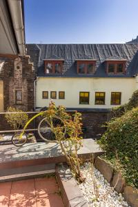 un vélo assis sur un banc devant une maison dans l'établissement Hotel Villa Tummelchen, à Cochem