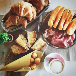 - une table avec trois assiettes de pain et de viennoiseries dans l'établissement Agriturismo Podere Campaini, à Volterra