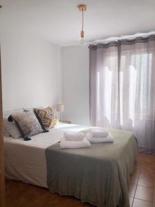 een slaapkamer met een bed met handdoeken erop bij Casa Alejandro Las Vistas in Arona