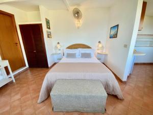 a bedroom with a large white bed and a bench at Residence Terra Rossa Taormina in Taormina