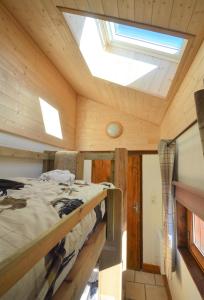 Jarrier的住宿－Le Petit Chalet-Leard，一间卧室配有一张床和天窗