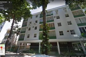 a large white building with a tree in front of it at Leblon House IV in Rio de Janeiro