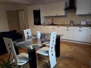 a kitchen with a dining room table and chairs at APART- salon z aneksem kuchenym, 2 sypialnie, łazienka in Szczecin