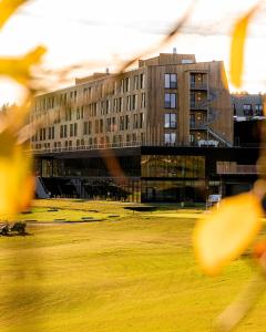 a building with a grass field in front of it at Lily Country Club in Klofta