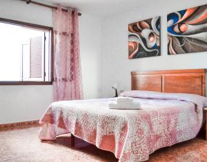 a bedroom with a bed with a wooden headboard and a window at Banana Surf House in Los Cristianos