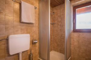 łazienka z prysznicem, toaletą i oknem w obiekcie Appartamento primo piano w mieście San Martino in Badia