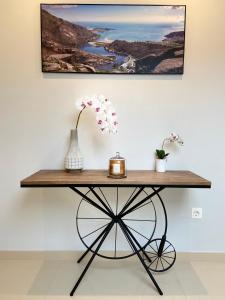 a wooden table with a vase and flowers on it at Pensión MarViva in Corcubión