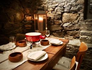 a wooden table with plates and wine glasses on it at Ca' Spontoi, Do-Minus Design Retreat & SPA in Bellinzona +38 photos