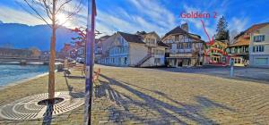 a cobblestone street in a town next to the water at Golden River in Unterseen