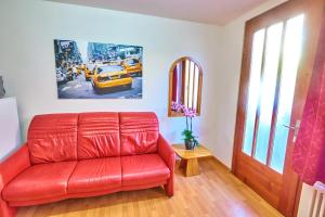 a red leather couch in a living room at Golden River in Unterseen