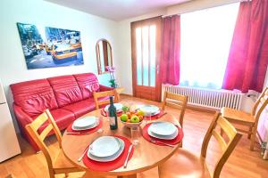 a living room with a table and a red couch at Golden River in Unterseen