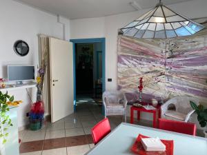 ein Wohnzimmer mit einem Tisch, Stühlen und einem Fenster in der Unterkunft Amarin Pisa Apartment in Pisa