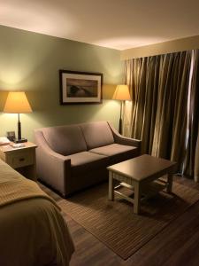 a hotel room with a couch and a table at 1000 Islands Harbor Hotel in Clayton