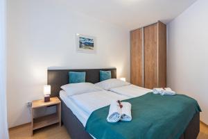 a bedroom with a large bed with towels on it at Wili Tatry Apartments in Tatranská Lomnica