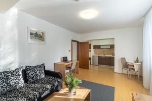 a living room with a couch and a kitchen at Wili Tatry Apartments in Tatranská Lomnica