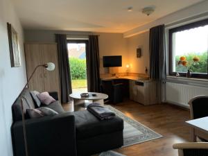 een woonkamer met een bank en een tafel bij Ferienwohnung Wiesenblick mit Terrasse im Landhaus Fischer in Sankt Andreasberg