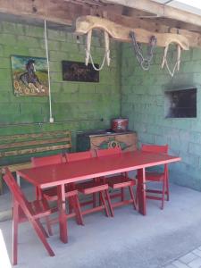Casa aconchegante em estilo rústico في بيراتوبا: طاولة نزهة حمراء مع كراسي حمراء في الغرفة