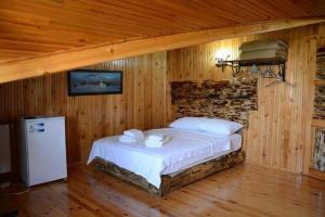 1 dormitorio con 1 cama en una habitación con paredes de madera en Ala Otel Konuk Evi Agva, en Sile