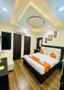 a bedroom with a large bed with an orange blanket at Hotel Kabir Residency in Amritsar