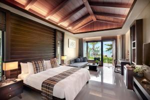 ein Schlafzimmer mit einem großen Bett mit einer Holzwand in der Unterkunft Khanom Beach Resort And Spa in Khanom