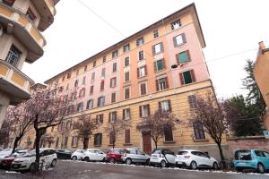Un gran edificio con coches aparcados delante. en Moon Bologna, en Bolonia