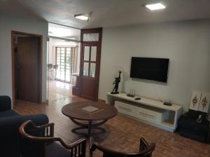 a living room with a tv and a table and chairs at Pousada Falls Park in Foz do Iguaçu