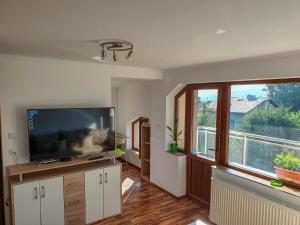 a living room with a flat screen tv and a large window at ALBISTO Dragalevtsi Luxury Apartments in Sofia