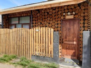 a house with a wooden door and a fence at Hotel Tehuelche Natura in Coihaique