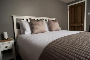 a bedroom with a large white bed with pillows at Courtyard at Crail in Crail
