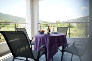 une table avec un chiffon de table violet sur un balcon dans l'établissement Casa Domenica, à Stavros