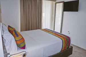 a bedroom with a white bed with at San Bernardo Hotel in Ríohacha