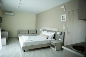 a white bedroom with a bed and a sink at Casa Domenica in Stavros